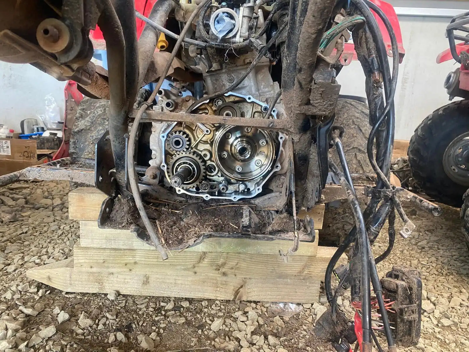 4-stroke motorcycle engine block with exposed gears and silver components.