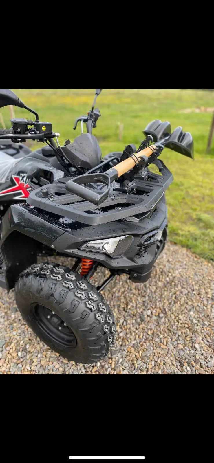 Black matte-finish atv with rugged off-road tires and a mounted fishing rod holder.