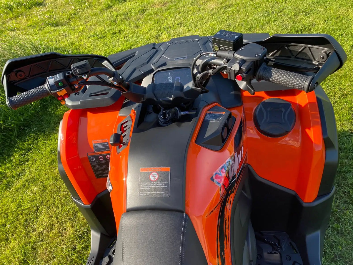 Orange and black polaris sportsman atv with textured grips, digital display, and rugged design.