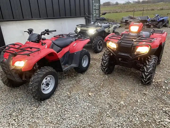 Red honda atv with black accents and rugged tires.