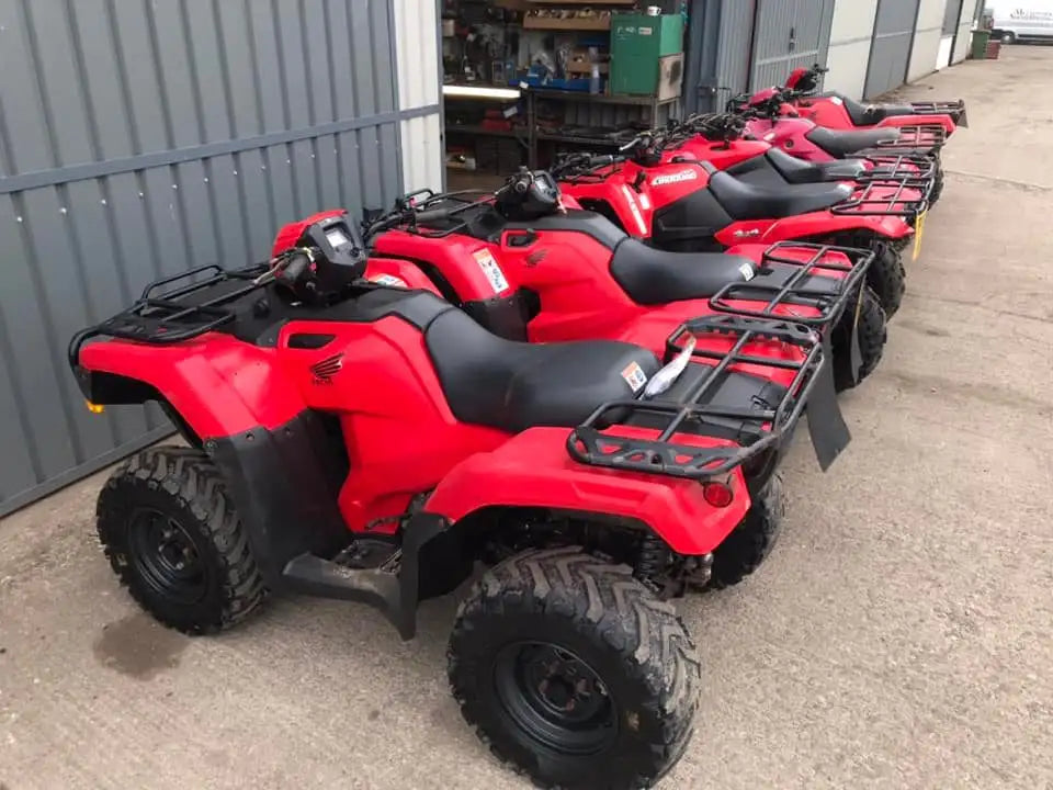 Red honda atv with black seat and cargo racks.