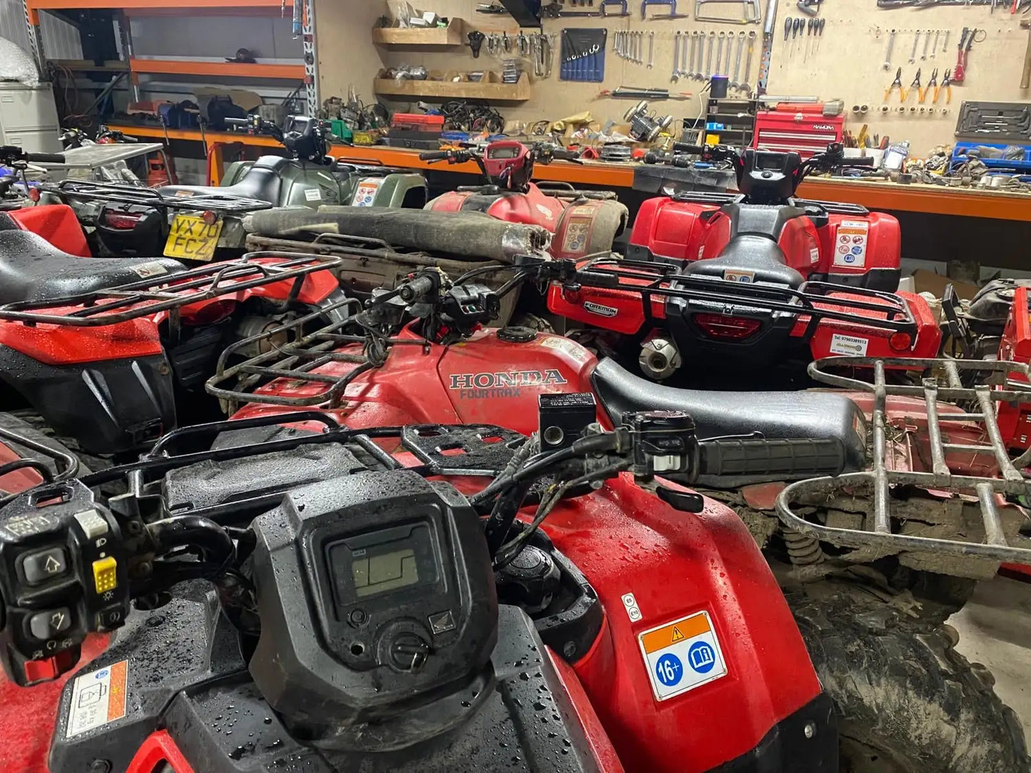 Red honda four-wheeler atv with black seat and handlebars.