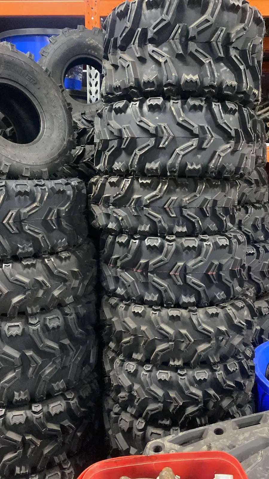 Stack of black, rugged off-road tires with deep treads.
