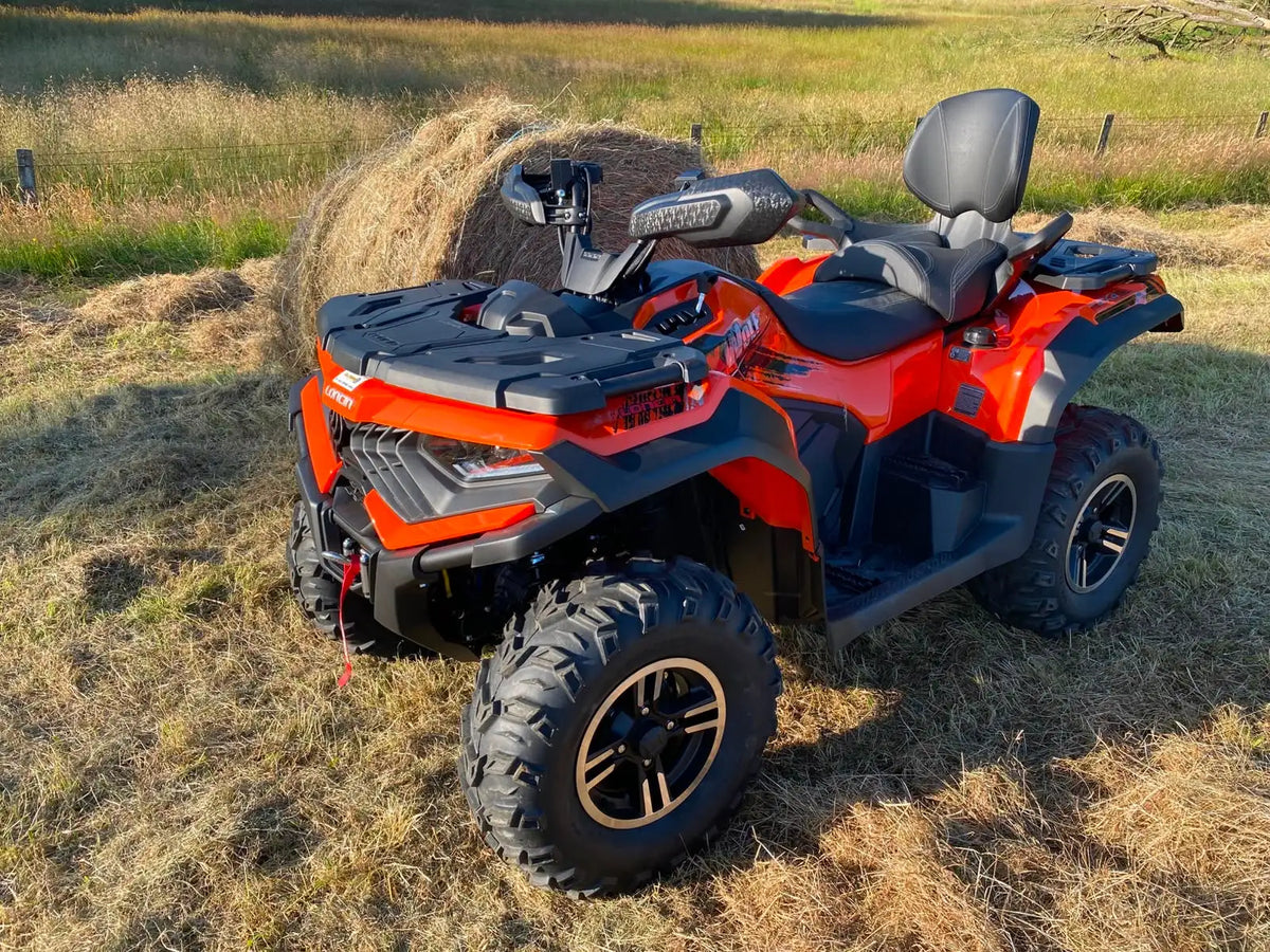 Vibrant orange and black can-am outlander atv with rugged off-road tires and a sleek, modern design.
